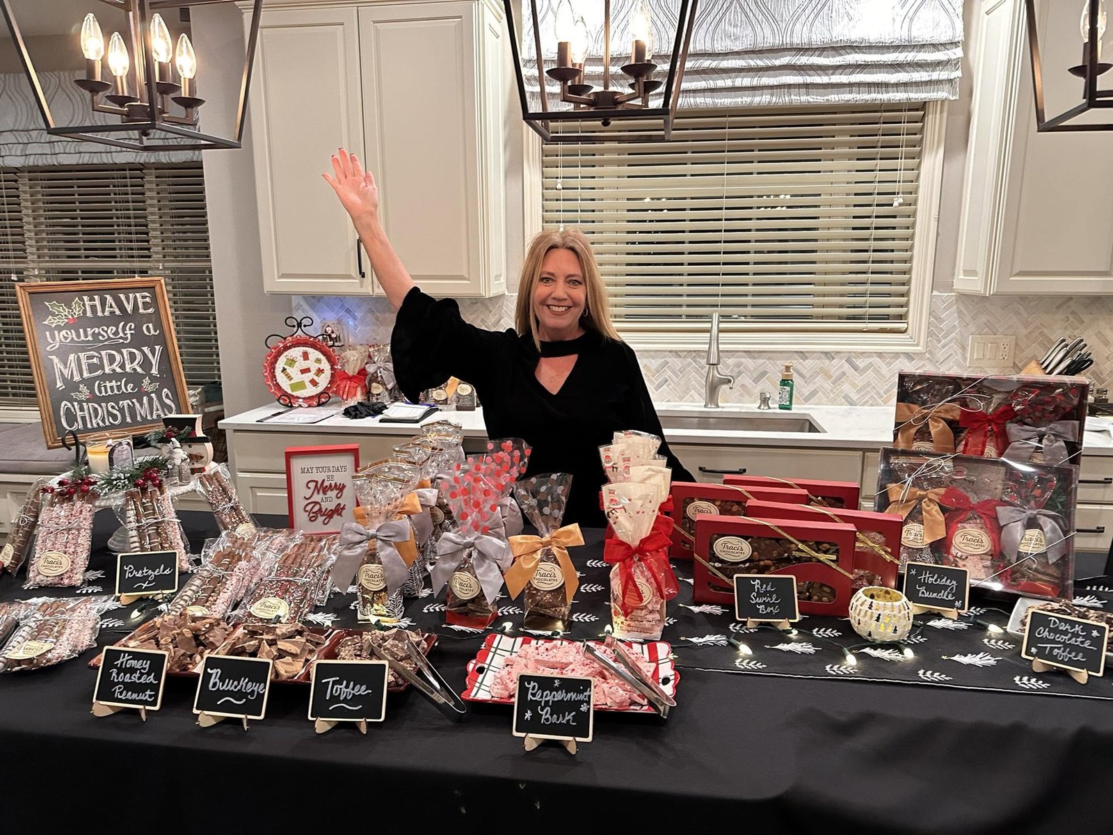 Traci smiling behind a table of her chocolates